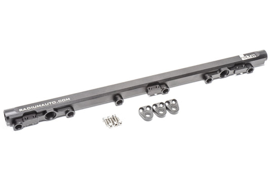 A black machined aluminum fuel rail for a Toyota 1JZ-GTE VVT-i engine, with anodized ports and included hardware.